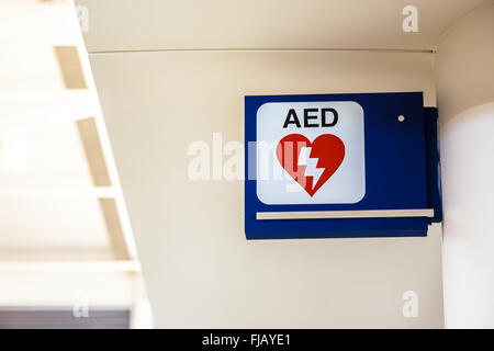 Automatisierter Externer Defibrillator AED Schild montiert an der Wand auf einem Flughafen. Stockfoto