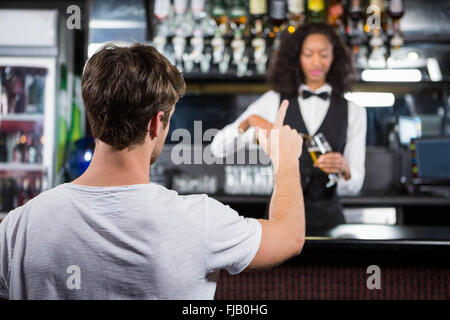 Mann einen Drink an der Theke bestellen Stockfoto