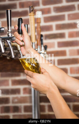 Gut aussehend Barkeeper einen Pint Bier in Strömen Stockfoto