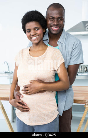 Schwangere paar umfassend in Küche Stockfoto