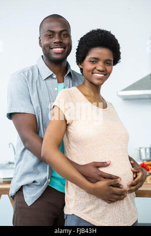 Schwangere paar umfassend in Küche Stockfoto