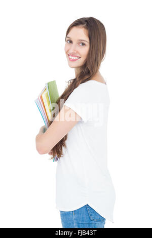 Seitenansicht des Lächelns weibliche College Student Holding Bücher Stockfoto