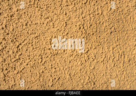 Gelbe groben Putz in das Sonnenlicht auf eine Hauswand. Genommen in Nahaufnahme. Stockfoto