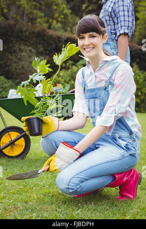 Junge Frau, die eine Pflanze Blumenerde Stockfoto