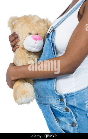 Schwangere Frau hält einen Teddybär Stockfoto