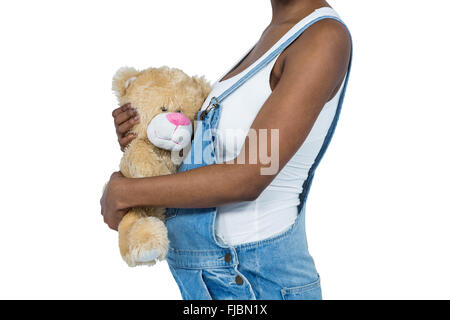 Schwangere Frau hält einen Teddybär Stockfoto