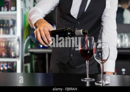 Mittleren Bereich der Barkeeper Rotwein in ein Glas gießen Stockfoto