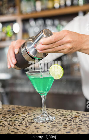 Gut aussehend Barkeeper einen Cocktail in ein Glas gießen Stockfoto