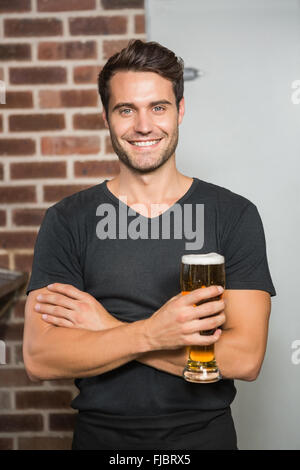 Gut aussehender Mann hält einen Pint Bier Stockfoto