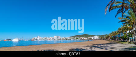 Mann im Wasser, Menschen am Strand in Antoni De Portmany, Ibiza am Wasser.  Gestrandete Segelboot weiter hinunter die Küste verlassen. Stockfoto