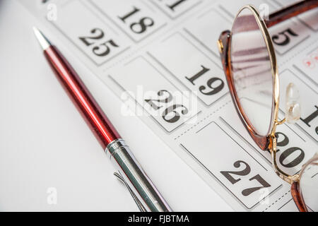 Stift und Brillen im Kalender Stockfoto