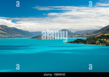 Blauer Himmel mit Wolken über den türkisblauen See, Lake Wakatipu, Schwein Insel hinter, in der Nähe von Queenstown, Neuseeland Stockfoto