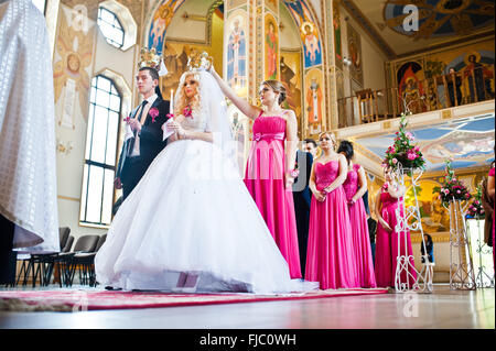 Stilvolle Trauzeugen und Brautjungfern mit Brautpaar in der Kirche Stockfoto