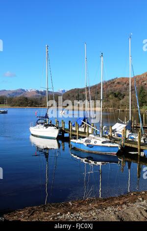 Yachten auf Holzsteg an Waterhead auf Windermere im englischen Lake District, Cumbria, England an einem ruhigen Wintertag. Stockfoto