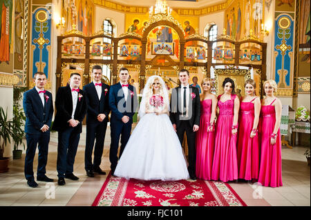 Stilvolle Trauzeugen und Brautjungfern mit Brautpaar in der Kirche Stockfoto