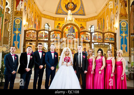 Stilvolle Trauzeugen und Brautjungfern mit Brautpaar in der Kirche Stockfoto