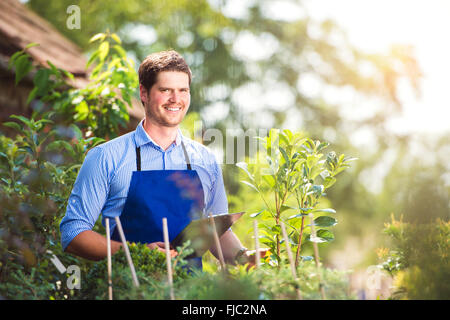 Gärtner halten Zwischenablage, in seinem Garten, grüne sonniges Gemüt Stockfoto