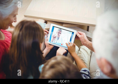 Zusammengesetztes Bild glücklich Arzt lächelnd in die Kamera und zeigt seine Stethoskop Stockfoto