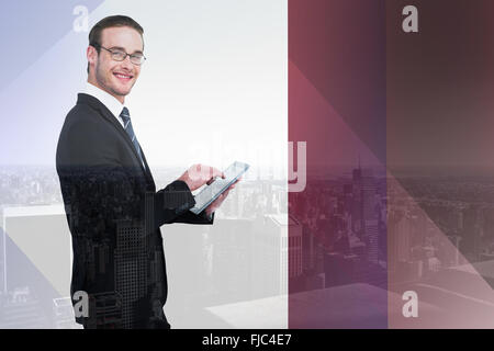Zusammengesetztes Bild des glücklichen Geschäftsmann mit seinem TabletPC Stockfoto