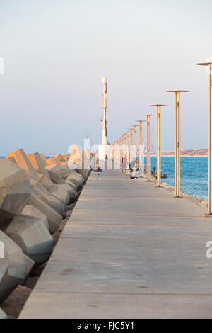 Fischer fangen Fische von einem Pier im Meer Stockfoto