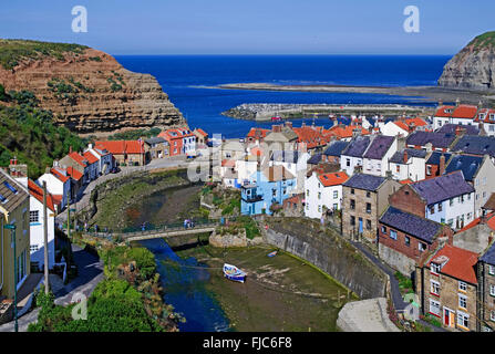 Blick über die Dächer in Richtung Hafen von der Küstenfischerei Dorf Staithes, Sommer, North Yorkshire, England UK Stockfoto