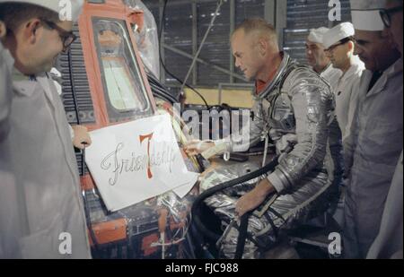 NASA Astronaut John Glenn und Techniker inspizieren Kunstwerk, das auf der Außenseite der sein Mercury-Raumschiff Friendship 7 am Kennedy Space Center in Cape Canaveral, Florida 10. Februar 1962 benannt lackiert werden. Glenn wurde der erste Amerikaner, der einen bemannten orbitalen Raumflug an Bord das Handwerk am 20. Februar 1962 zu fliegen. Stockfoto