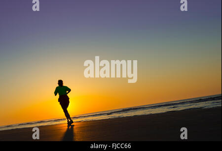 Sunrise-Jogger am Strand Stockfoto