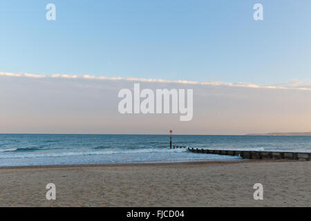 ein Abendlicht, Blick auf einem Steg am Strand mit Sand und ein Flugzeug-Cloud auf einem Winkel getroffen Stockfoto