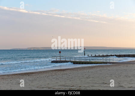 ein Abendlicht, Blick auf einem Steg am Strand mit Sand und ein Flugzeug-Cloud auf einem Winkel getroffen Stockfoto