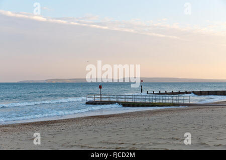 Goldene Abendlicht eines Vogels fliegen in den Himmel am Meer, Blick auf einem Steg am Strand mit Sand und ein Flugzeug rosa Col getroffen Stockfoto