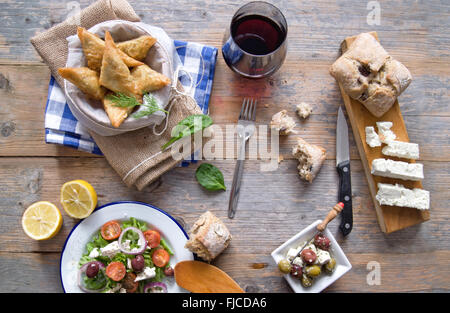 Feta-Käse und Spinat Blätterteig-Gebäck und griechischer Salat auf einem Holztisch gelegt Stockfoto