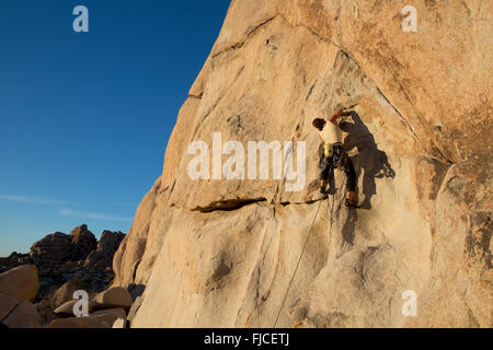 Frau Klettern im Hidden Valley, Joshua Tree Nationalpark Kalifornien USA Stockfoto