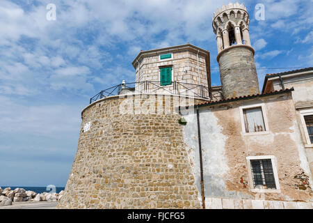 Piran Kirche von St. Clemens und Punta Madonna mit Leuchtturm Gebäude in Slowenien Stockfoto