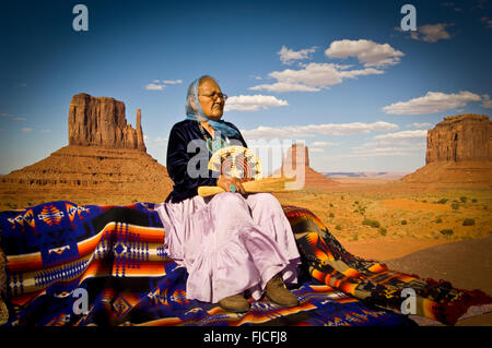 Navajo Indianerin in traditioneller Tracht auf Navajo Decke sitzen. Monument Valley Tribal Denkmal, Arizona, USA Stockfoto