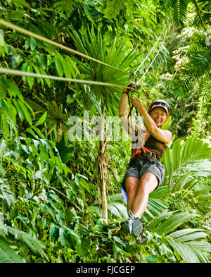 Frau, die eine gute Zeit Reißverschluss Futter über Dschungel Baldachin. Pacuare Fluss, Costa Rica Stockfoto