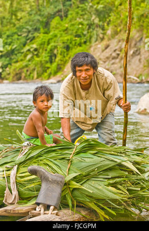 Menschen, indigenen Cabecar Indianer Stamm Vater und Sohn, die Überquerung des unteren Pacuare Flusses auf einem handgefertigten Log Floß, Costa Rica Stockfoto