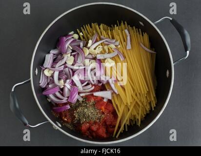 Die Zutaten für eine Topfpflanze basierte Nudelgericht in einen Topf geben. Stockfoto