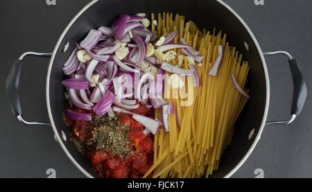 Die Zutaten für eine Topfpflanze basierte Nudelgericht in einen Topf geben. Stockfoto