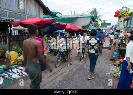 Fish and Flower Market Street Scene Mandalay Myanmar // MANDALAY, Myanmar – Eine Straßenszene auf einem Fisch- und Blumenmarkt in der Nähe der Pulaing Street in Mandalay. Der Markt ist eines der traditionellen Geschäftsviertel in Myanmars zweitgrößter Stadt und ehemaliger königlicher Hauptstadt. Mandalay ist das wirtschaftliche und kulturelle Zentrum von Upper Myanmar, das sich im zentralen Teil des Landes am Ayeyarwady River (auch bekannt als Irrawaddy River) befindet. Die Stadt wurde 1857 von König Mindon als neue königliche Hauptstadt der Konbaung-Dynastie gegründet. Traditionelle Märkte wie dieser bleiben ein integraler Bestandteil des täglichen Kommens Stockfoto