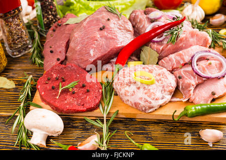 Top-down Ansicht auf überfüllten Sortiment von verschiedenen Fleischsorten, Paprika, Tomaten, Kräutern, Gewürzen und anderen Zutaten Stockfoto