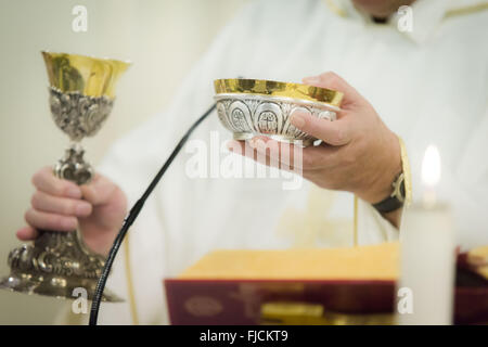 Priester feiern die Kommunion mit Kelch und heilige Brot Stockfoto