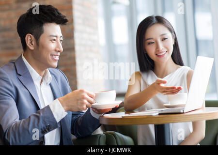 Chinesische Unternehmerin und Unternehmer arbeiten mit Laptop im café Stockfoto