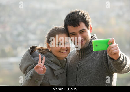 junges Paar, Mann und Frau vor Rheine Fluss, Deutschland, macht Selfie, Foto mit Ihrem Smartphone Stockfoto