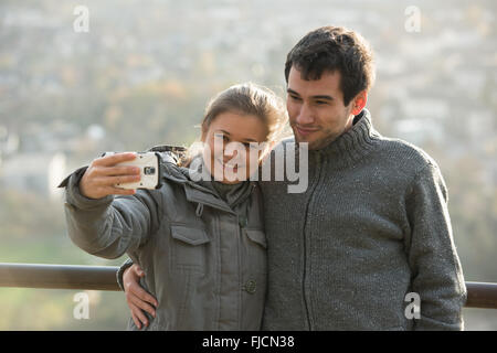 junges Paar, Mann und Frau vor Rheine Fluss, Deutschland, macht Selfie, Foto mit Ihrem Smartphone Stockfoto