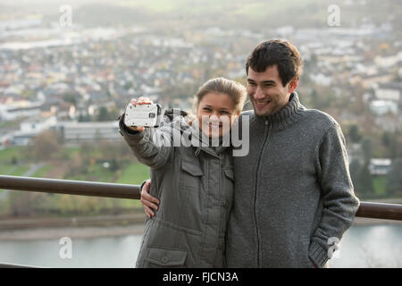 junges Paar, Mann und Frau vor Rheine Fluss, Deutschland, macht Selfie, Foto mit Ihrem Smartphone Stockfoto