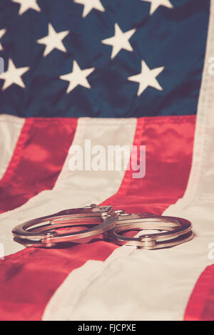 Handschellen mit einer amerikanischen Flagge Hintergrund. Stockfoto