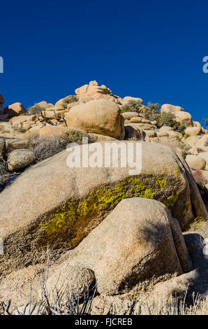 Loses Gestein Berg mit grünem Moos gegen blauen Himmel Stockfoto