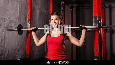 Junge attraktive Sportlerin mit einer Langhantel. Sportclub. Fitness-Club. Gesunder Lifestyle-Konzept. Stockfoto