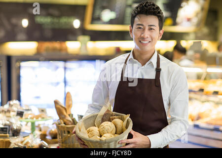 Junge chinesische Mann arbeitet in der Bäckerei Stockfoto
