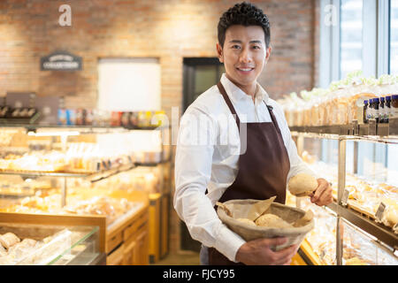 Junge chinesische Mann arbeitet in der Bäckerei Stockfoto